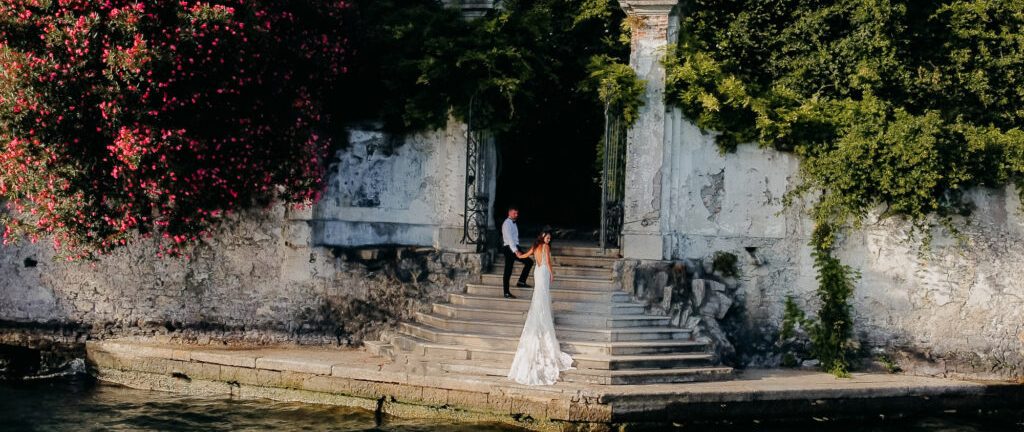 A married couple holding hands on a vintage Riva speedboat on Lake Como